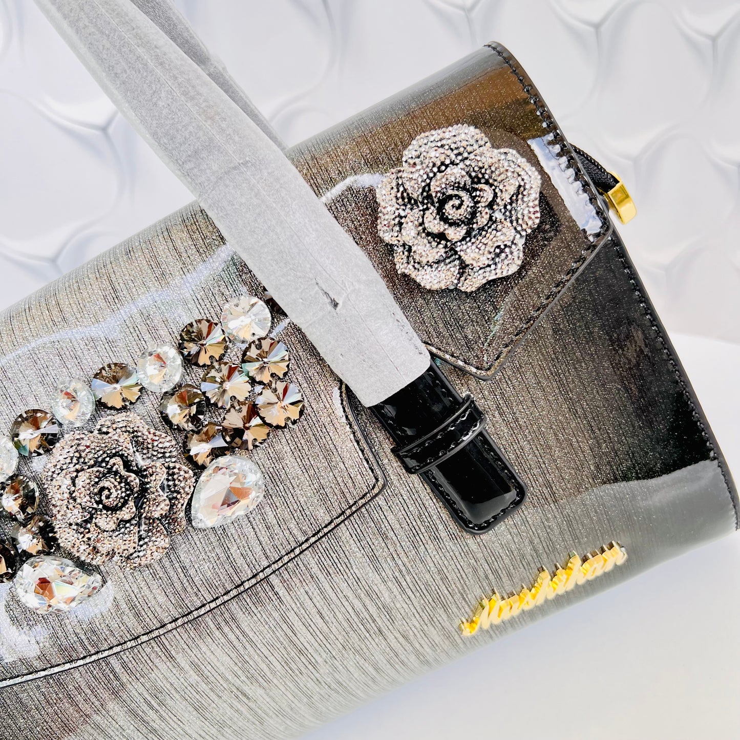 Designer shining leather handbag with stonework