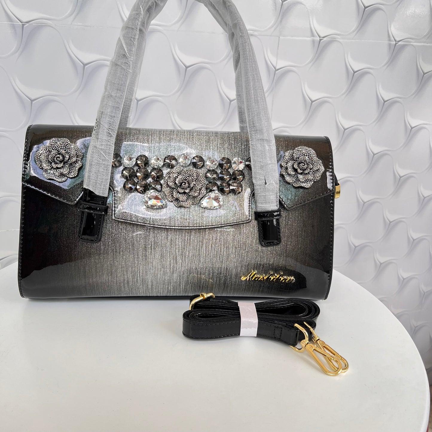 Designer shining leather handbag with stonework