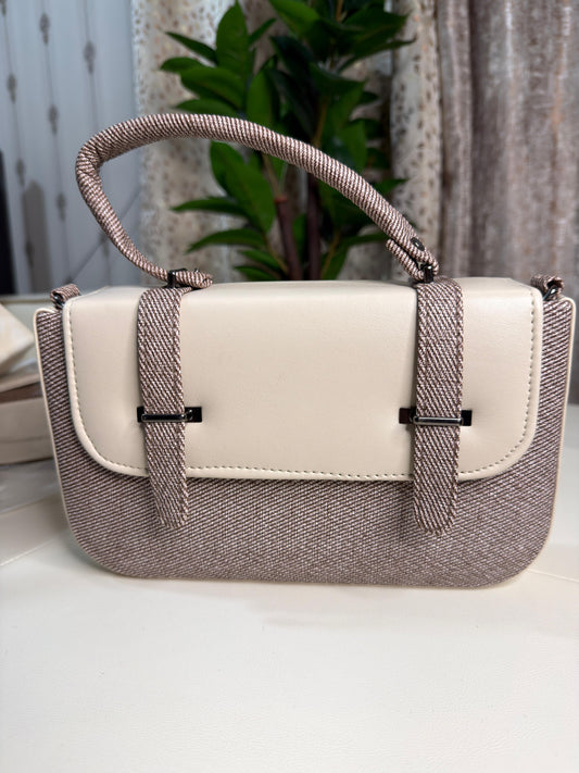 Handbag with beige top section and brown textured bottom on a white surface.