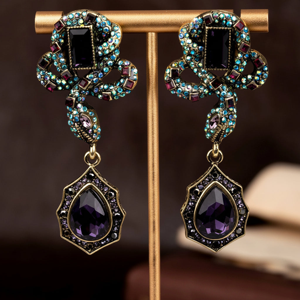 Pair of ornate earrings with purple stones on a stand against a dark background