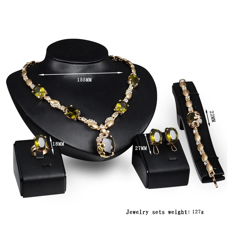Jewelry set with necklace, earrings, and bracelet on a black stand with a white background