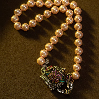 Pearl necklace with a decorative pendant on a brown background
