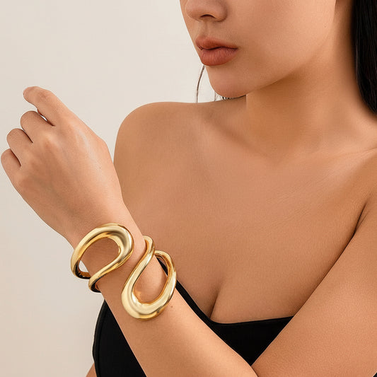 Woman wearing a gold bracelet on a neutral background