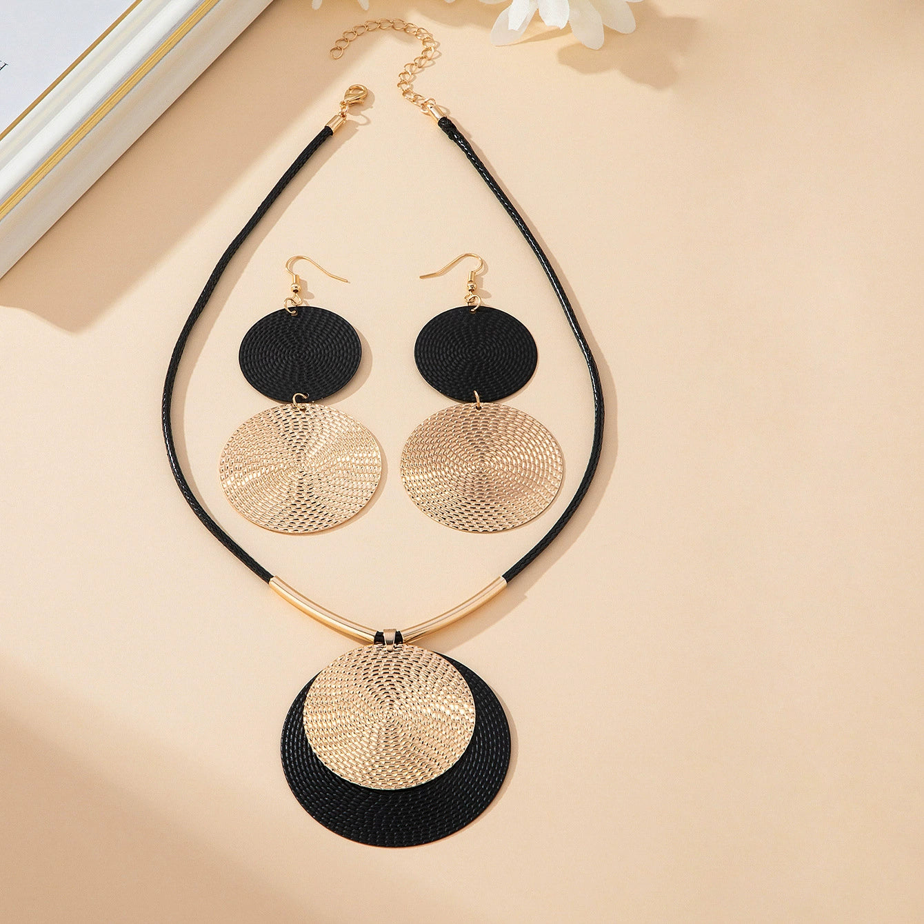 Jewelry set with necklace and earrings on a beige background
